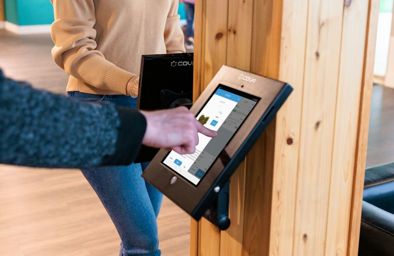 Person bedient ein Tablet-Terminal an der Wand
