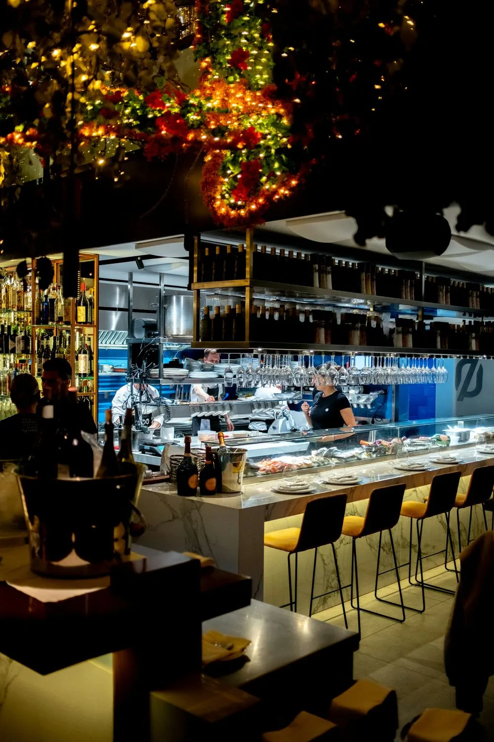 Volles Restaurant am Abend mit Küche im Hintergrund